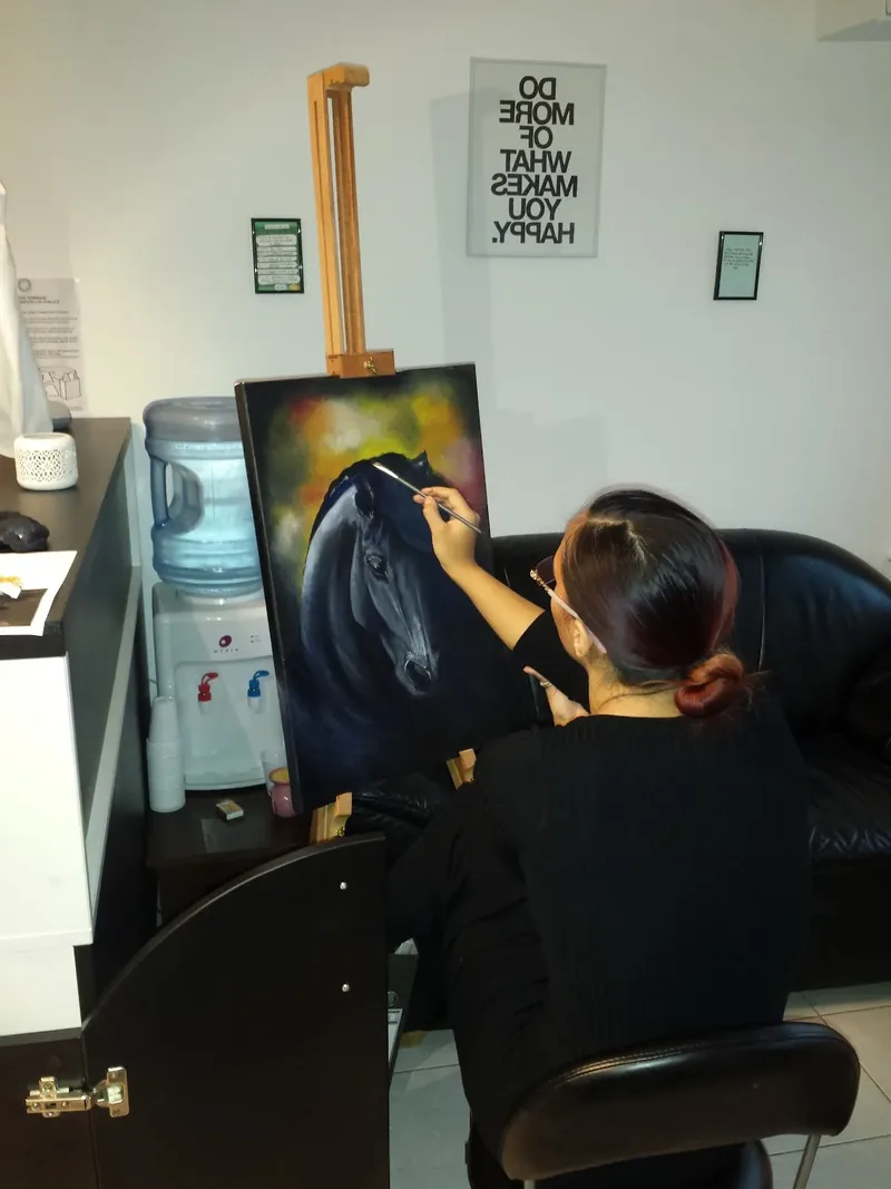 Artistă pictând pe șevalet în studio